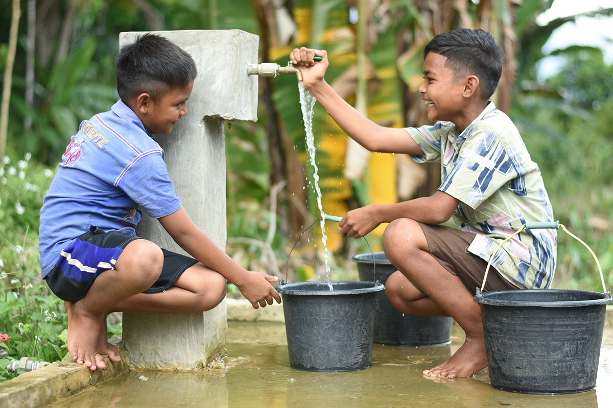 Dimas and Nanda filling up buckets