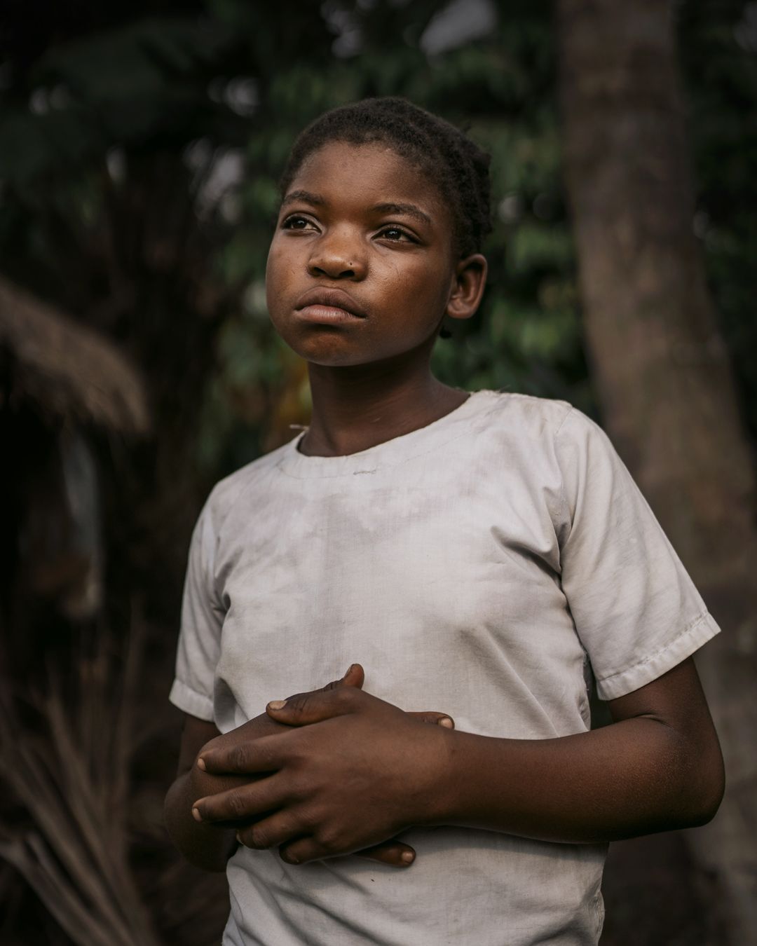 A portrait of Adel, 13, near her home, in Kasai, DRC
