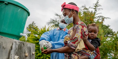 Een moeder wast haar handen in een gezondheidscentrum na het volgen van de instructies over ebola.