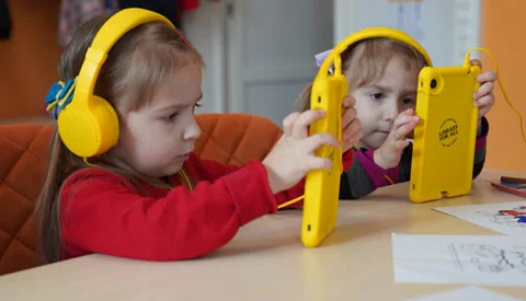 twee meisjes volgen onderwijs via een tablet