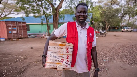 Save the Children medewerker met een doos goederen - Zuid-Soedan