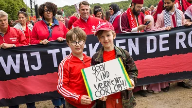 Rode Lijn protest: twee jongens met een borg met de tekst 'geen kind verdient oorlog'