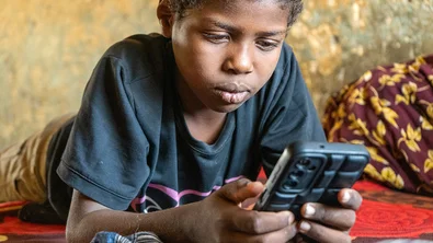Een jongen zit op zijn telefoon