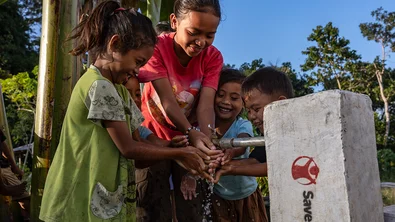 Kinderen in Indonesië staan bij een kraan