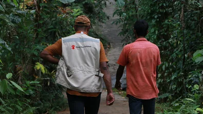 Medewerker van Save the Children wandelt met een man