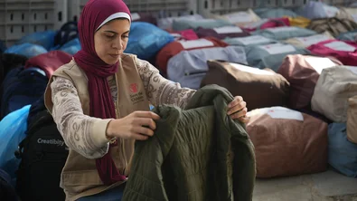 Shurouq houdt een jas uit een winterkit vast