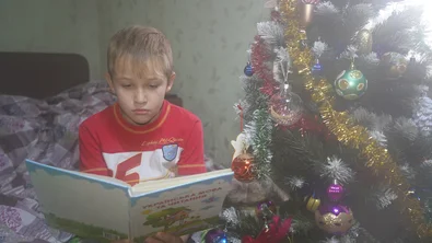 Ivan studeert in zijn huis met kerst door een kerstdonatie