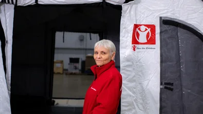 Rachel Pounds bij een tent van Save The Children