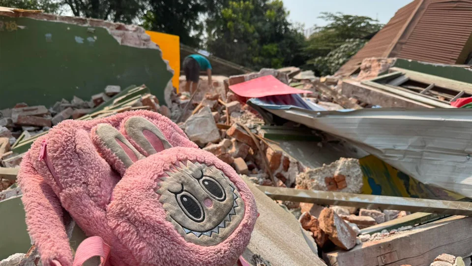 Roze pluchen kinderrugzak in het puin in Mandalay, Myanmar