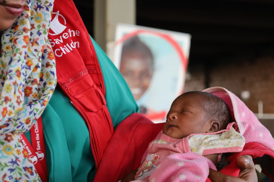 Mederwerker Save the Children met pasgeboren baby Sara