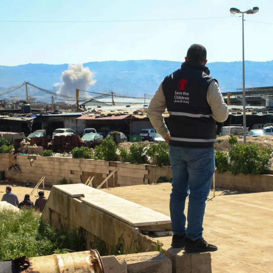 Save the Chilren staff watches smoke after strike in Beirut