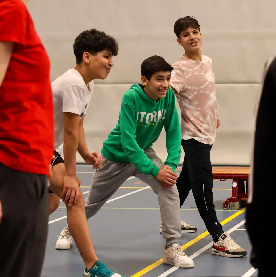 kinderen onder begeleiding sporten in gymzaal