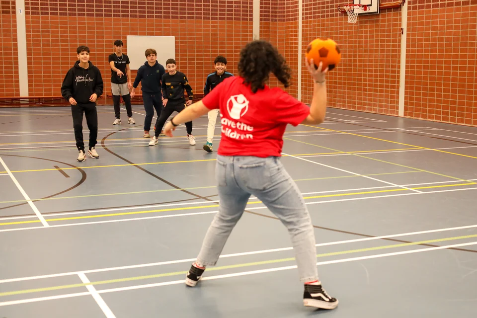 balspel groep kinderen en begeleider in een gymzaal