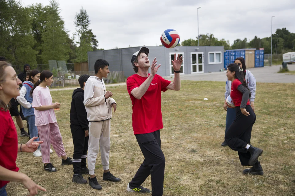 begeleiders en kinderen aan het sporten met bal