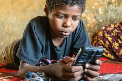 Een jongen zit op zijn telefoon Een jongen zit op zijn telefoon