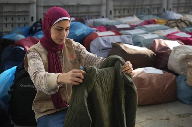 Shurouq houdt een jas uit een winterkit vast