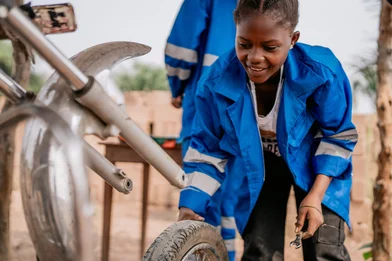 Door Save The Children getrainde monteur Bea werkt aan een motor