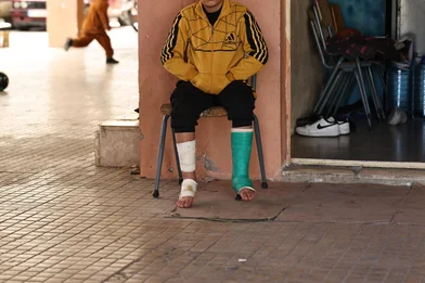 11-year old boy sits with broken foot at the collective shelter