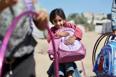 Een meisje nadat ze een schooltas en schoolkit heeft gekregen van Save the Children.
