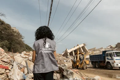 Save the Children hulpverlener staat bij een plek die getroffen is door een aardbeving