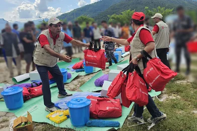 Medewerkers van Save the Children delen hygiënepakketten uit aan een gemeenschap die getroffen is door de plotselinge overstroming