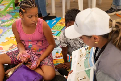 Save the Children medewerker leest een verhaal voor aan Emma en andere kinderen*
