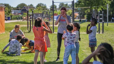 Kinderen spelen in een groep onder leiding van een TeamUp vrijwilliger