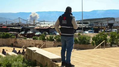 Save the Children staff watching smoke after a strike in Beirut