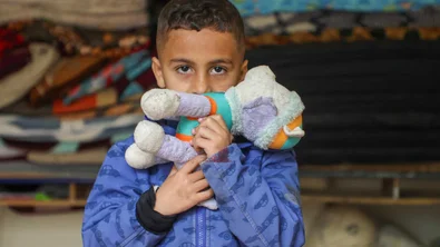 Kind houdt knuffel vast in collectieve opvang in Libanon