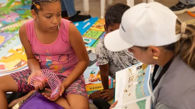 Save the Children medewerker leest een verhaal voor aan Emma en andere kinderen*
