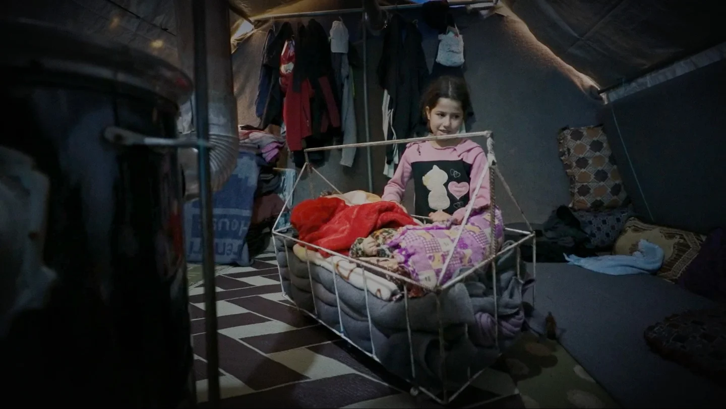 Afganistan, Jannat, 9 jaar, wiegt de baby in het bedje