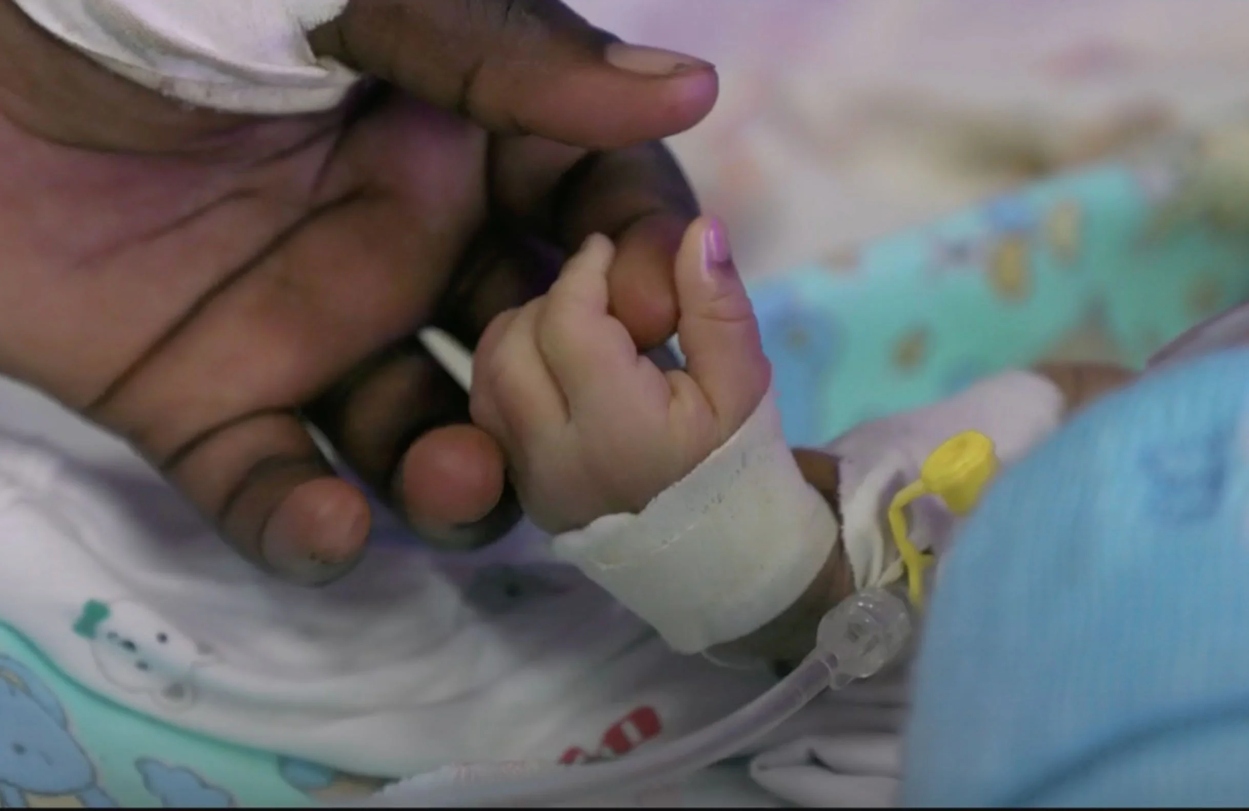 Babyhandje houdt hand vast in medische setting