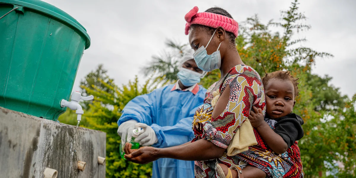 Een moeder wast haar handen in een gezondheidscentrum na het volgen van de instructies over ebola.