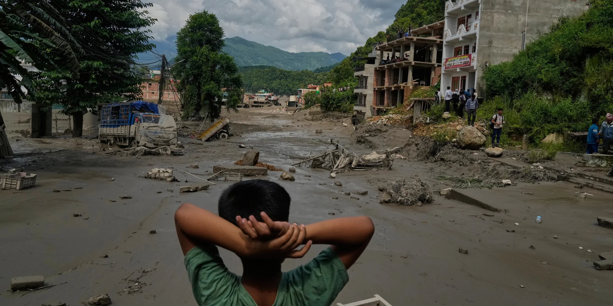 Jongen kijkt naar de schade van de overstroming in Nepal